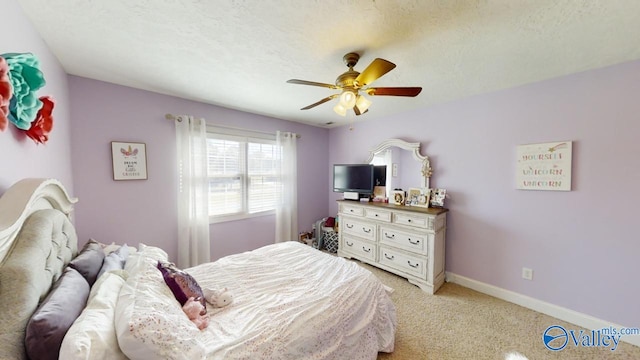 bedroom featuring ceiling fan, light colored carpet, and a textured ceiling