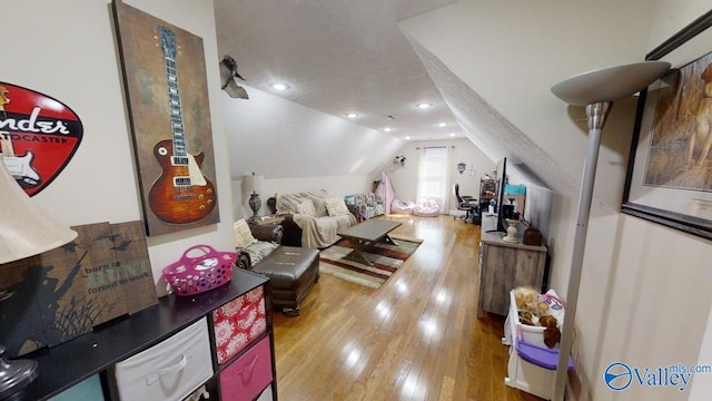 interior space featuring lofted ceiling, hardwood / wood-style floors, and a textured ceiling