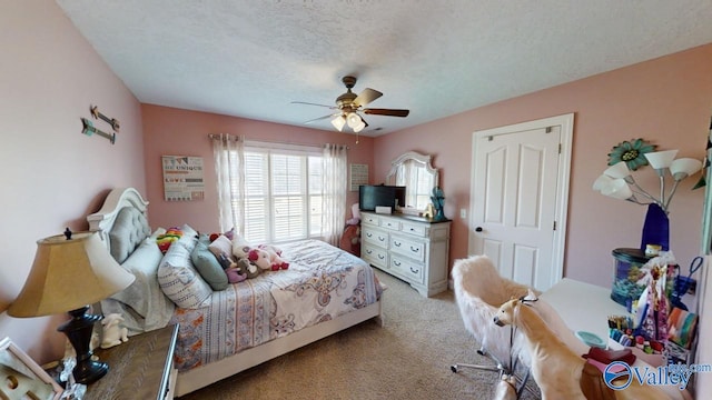 carpeted bedroom with a textured ceiling and ceiling fan