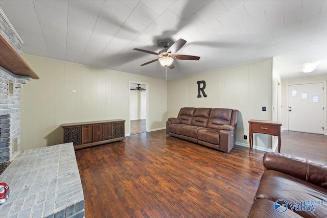 living room featuring ceiling fan, a fireplace, and dark hardwood / wood-style flooring