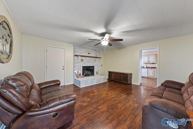 living room featuring ceiling fan, a fireplace, and dark hardwood / wood-style flooring