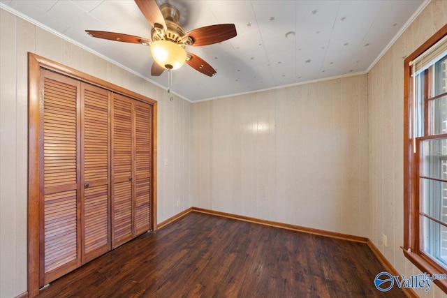 unfurnished bedroom featuring crown molding, ceiling fan, dark hardwood / wood-style flooring, and a closet