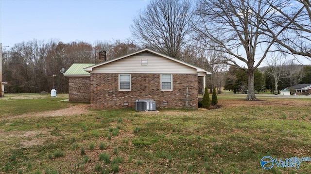 view of side of home with cooling unit and a lawn