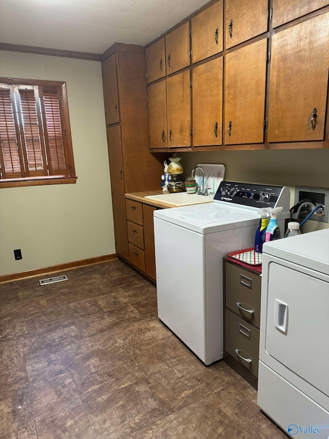 washroom with cabinets, separate washer and dryer, and sink