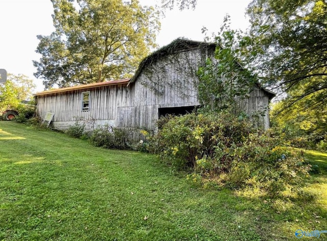 view of side of home with a lawn and an outdoor structure