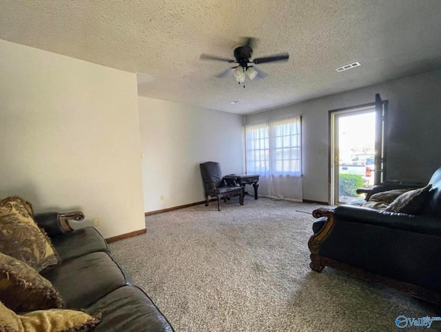 carpeted living room featuring ceiling fan and a textured ceiling