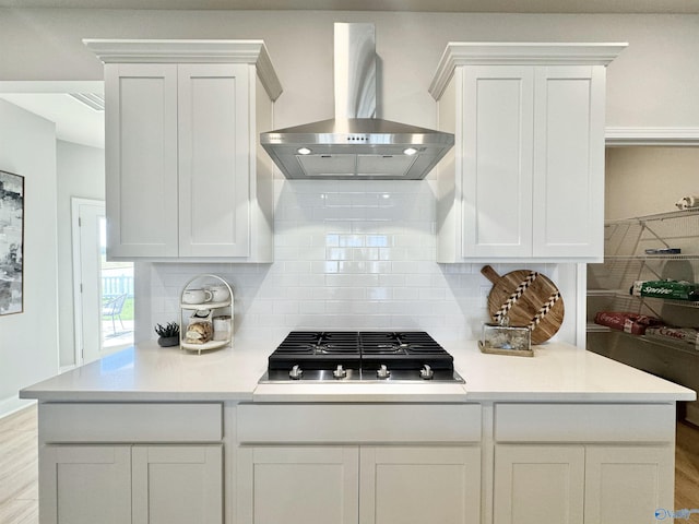 kitchen featuring stainless steel gas cooktop, light hardwood / wood-style floors, island range hood, and white cabinets