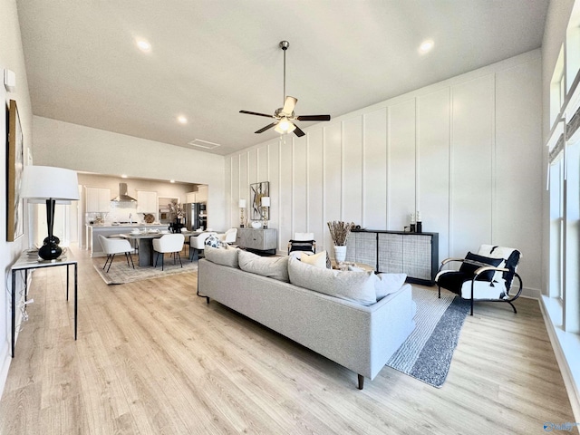 living room featuring ceiling fan and light hardwood / wood-style flooring