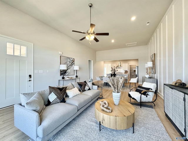 living room with ceiling fan and light hardwood / wood-style flooring