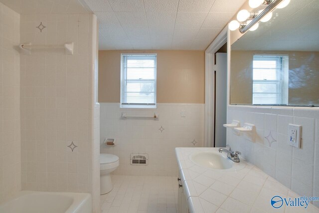 8201 Willowbrook Cir Unit B, Huntsville, AL 35802 - full bathroom featuring tile walls, plenty of natural light, toilet, vanity, and tile patterned floors