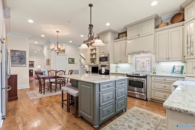 kitchen with stainless steel appliances, light wood-type flooring, gray cabinets, a center island, and crown molding