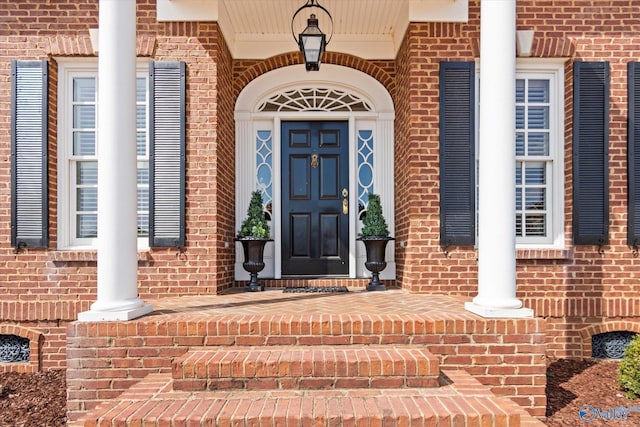 entrance to property featuring brick siding