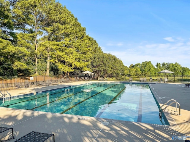 pool with a patio and fence