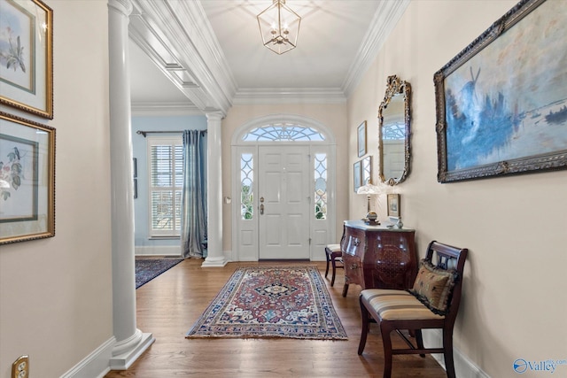 entryway with crown molding, decorative columns, and wood finished floors