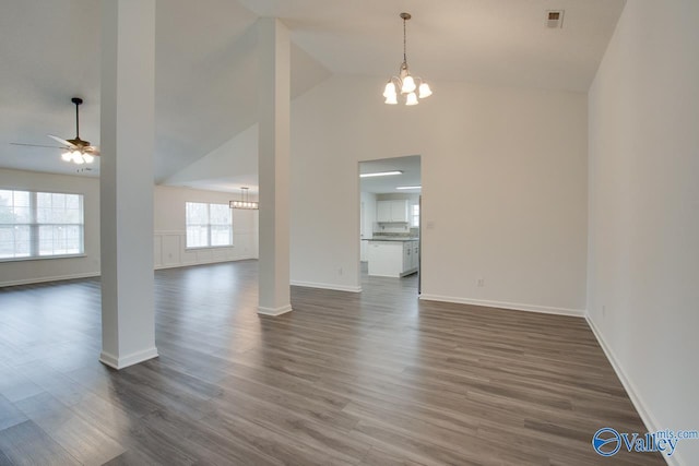 unfurnished living room featuring high vaulted ceiling, ceiling fan with notable chandelier, dark wood-type flooring, visible vents, and baseboards