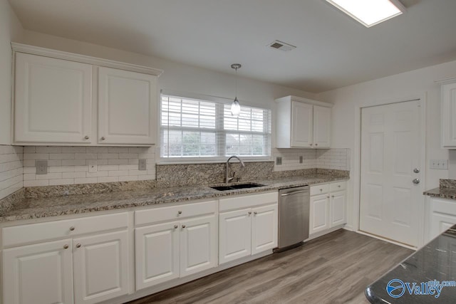 kitchen with white cabinetry, dishwasher, visible vents, and a sink