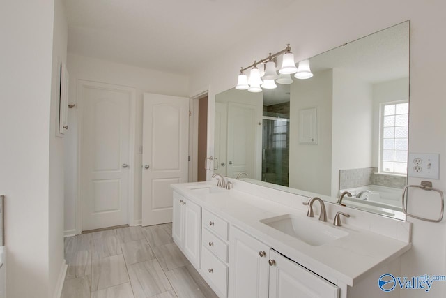 bathroom with double vanity, a sink, a bath, and a shower stall