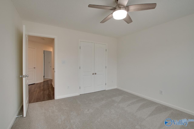 unfurnished bedroom with carpet, a closet, ceiling fan, and baseboards