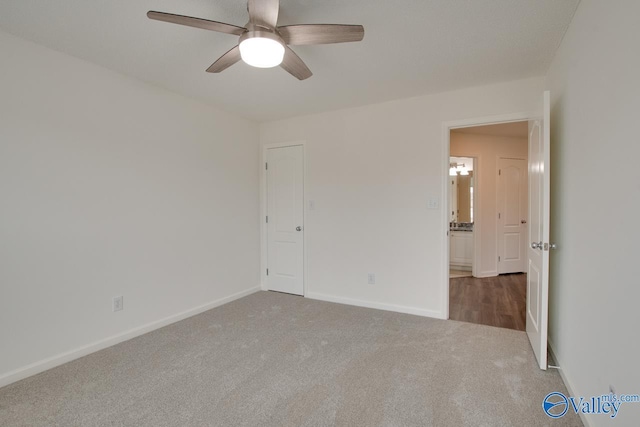 unfurnished room featuring a ceiling fan, dark colored carpet, and baseboards