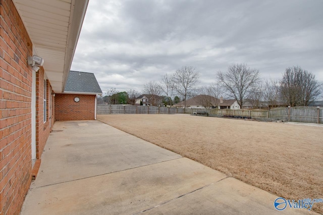 view of yard with a patio area, a fenced backyard, and a residential view