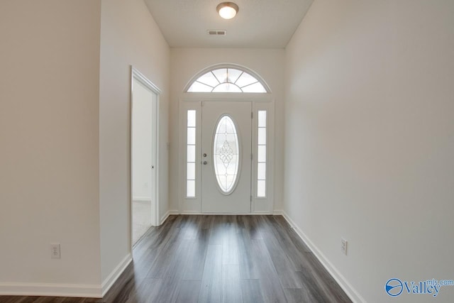 foyer with visible vents, dark wood finished floors, a textured ceiling, and baseboards