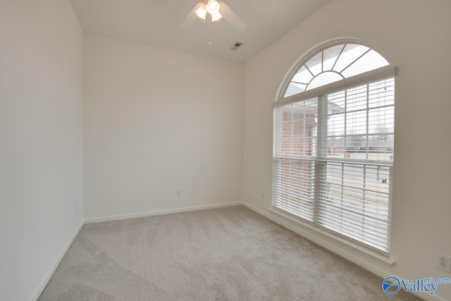 unfurnished room featuring baseboards, visible vents, a ceiling fan, light colored carpet, and vaulted ceiling