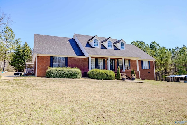 cape cod house with roof with shingles, a porch, a front lawn, and brick siding