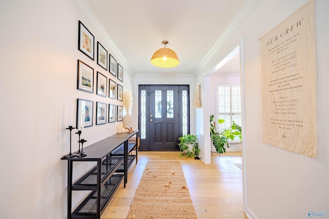 foyer featuring light wood-style flooring and crown molding