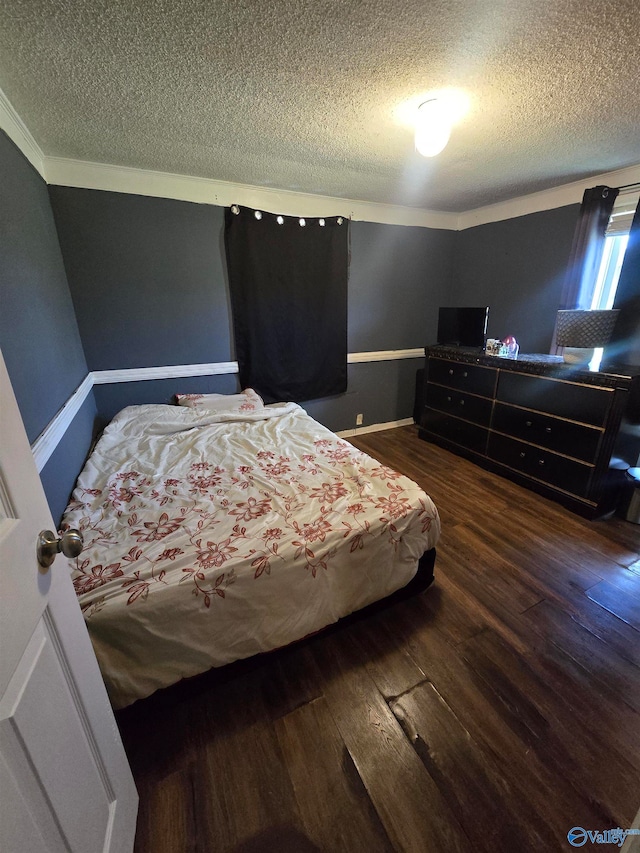 bedroom with dark hardwood / wood-style floors, crown molding, and a textured ceiling