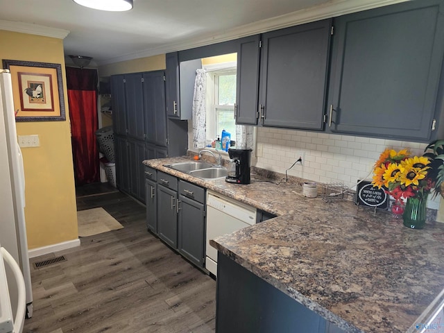 kitchen featuring decorative backsplash, dark hardwood / wood-style flooring, ornamental molding, white appliances, and sink