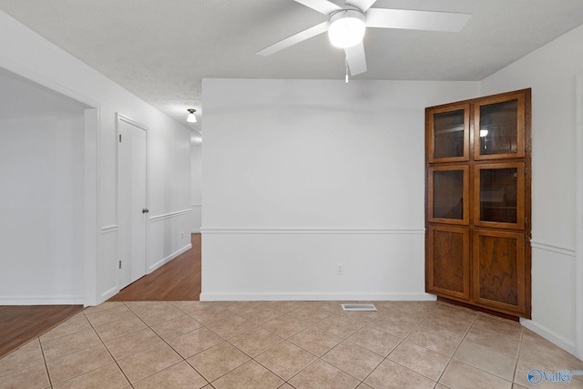 unfurnished room featuring light tile patterned floors and ceiling fan