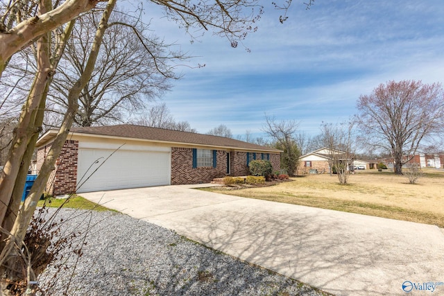 view of front of house with a front yard, a garage, brick siding, and driveway