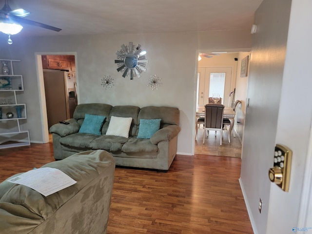 living room with dark wood-type flooring and ceiling fan