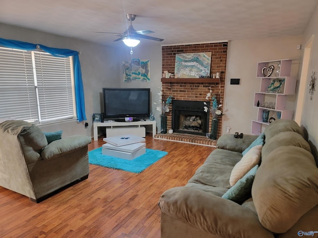 living room featuring ceiling fan, a brick fireplace, and hardwood / wood-style floors