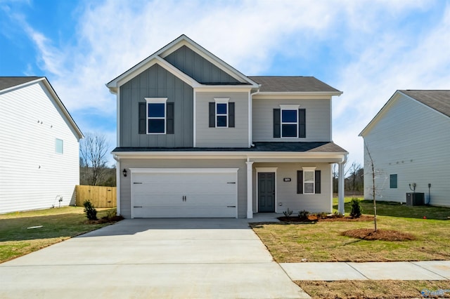 view of front of home featuring a garage, a front yard, and central AC unit