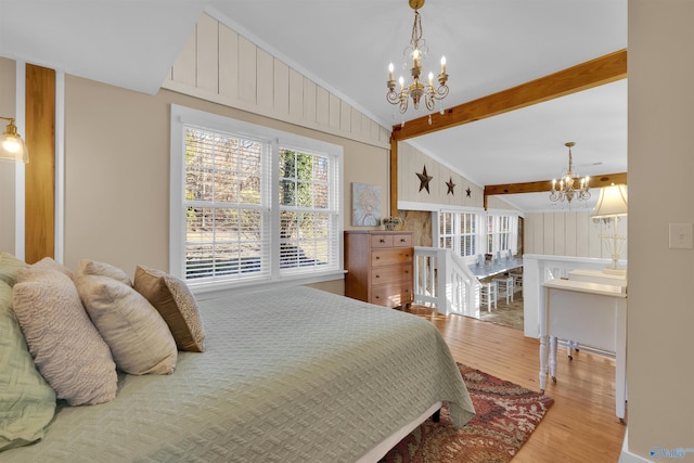 bedroom featuring a chandelier, lofted ceiling with beams, and wood finished floors