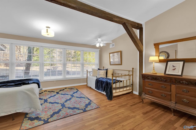 bedroom featuring visible vents, light wood-style flooring, vaulted ceiling with beams, and baseboards