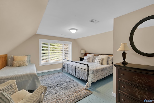 bedroom featuring visible vents, lofted ceiling, and hardwood / wood-style floors