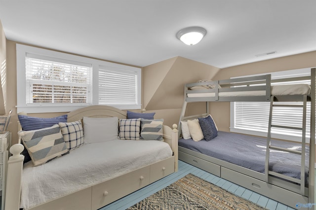 bedroom featuring vaulted ceiling and visible vents