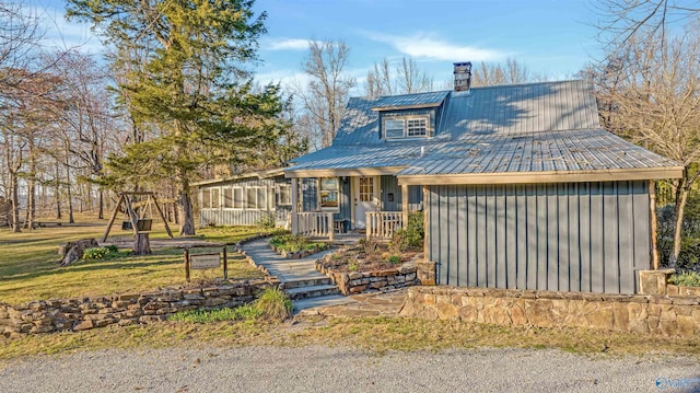 view of front of house with a chimney and metal roof