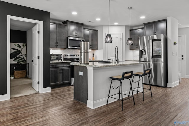 132 Fall Meadow Dr, Harvest, AL 35749 - kitchen featuring appliances with stainless steel finishes, dark wood-style floors, a sink, light stone countertops, and recessed lighting