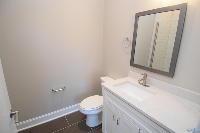 bathroom with tile patterned flooring, vanity, baseboards, and toilet