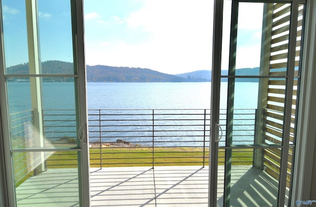 doorway to outside with a wealth of natural light and a water and mountain view