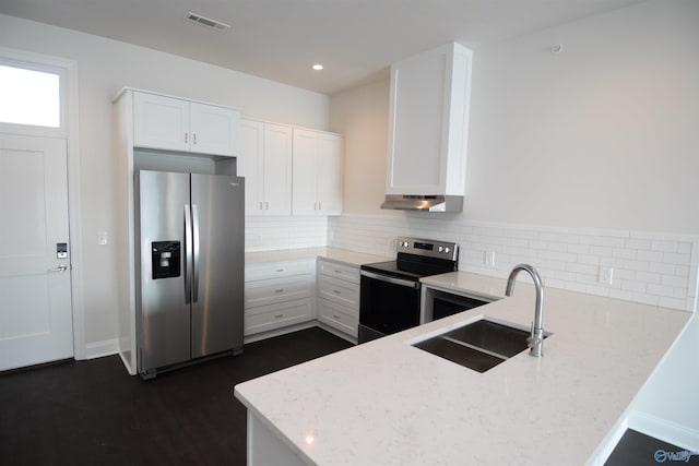kitchen featuring a peninsula, visible vents, appliances with stainless steel finishes, under cabinet range hood, and a sink
