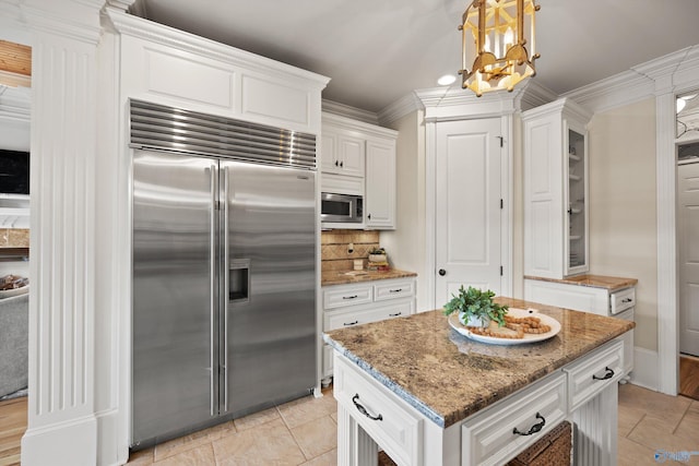 kitchen featuring crown molding, built in appliances, white cabinets, and light stone counters