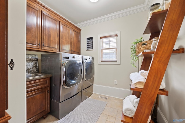 laundry area with cabinets, ornamental molding, sink, and washing machine and clothes dryer