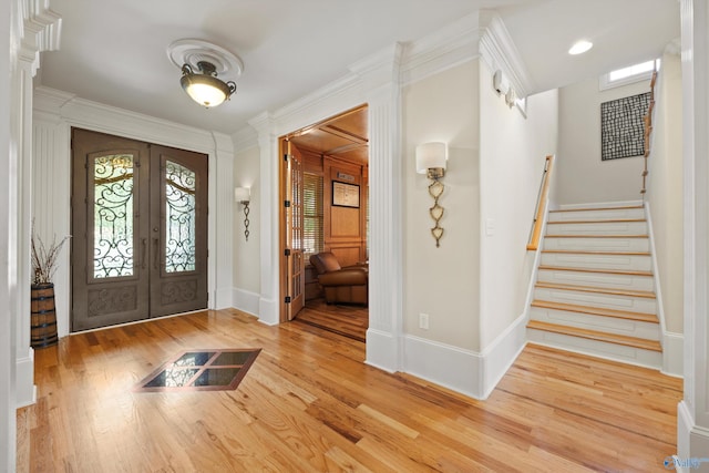 foyer with french doors, ornamental molding, and hardwood / wood-style flooring