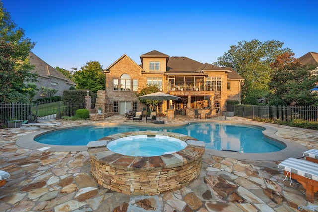 view of pool featuring an in ground hot tub, a fireplace, and a patio