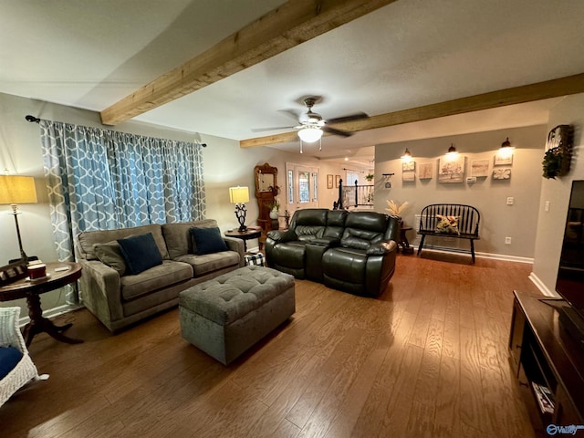 living area featuring ceiling fan, wood-type flooring, beam ceiling, and baseboards