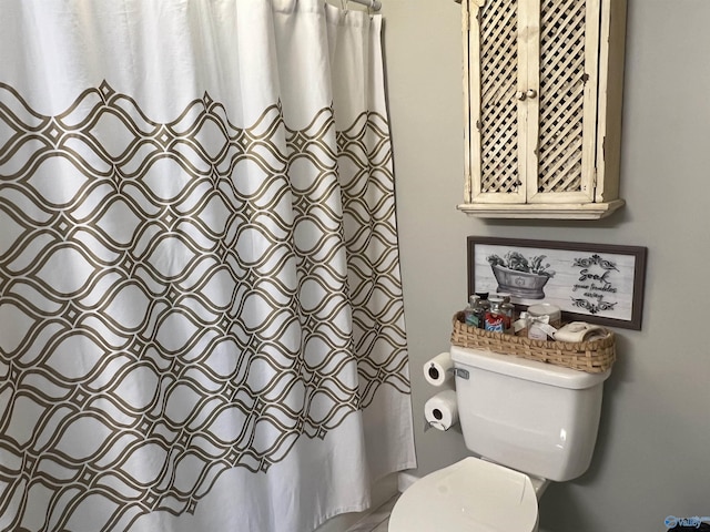 full bath with toilet and a shower with shower curtain